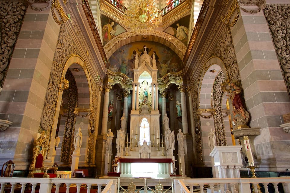 Interno di una chiesa decorata, con un altare centrale, statue e dettagli architettonici elaborati.