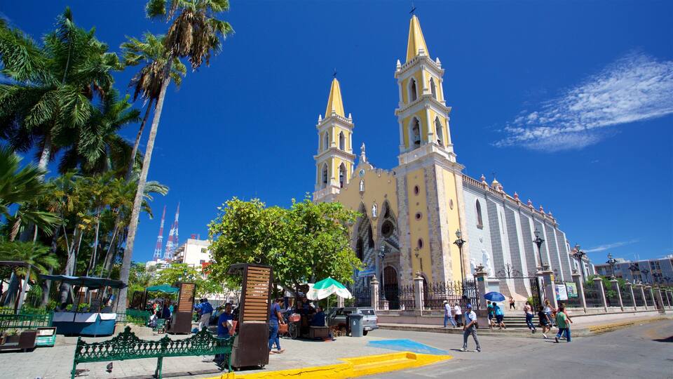 A large yellow church with two towers and a blue sky.