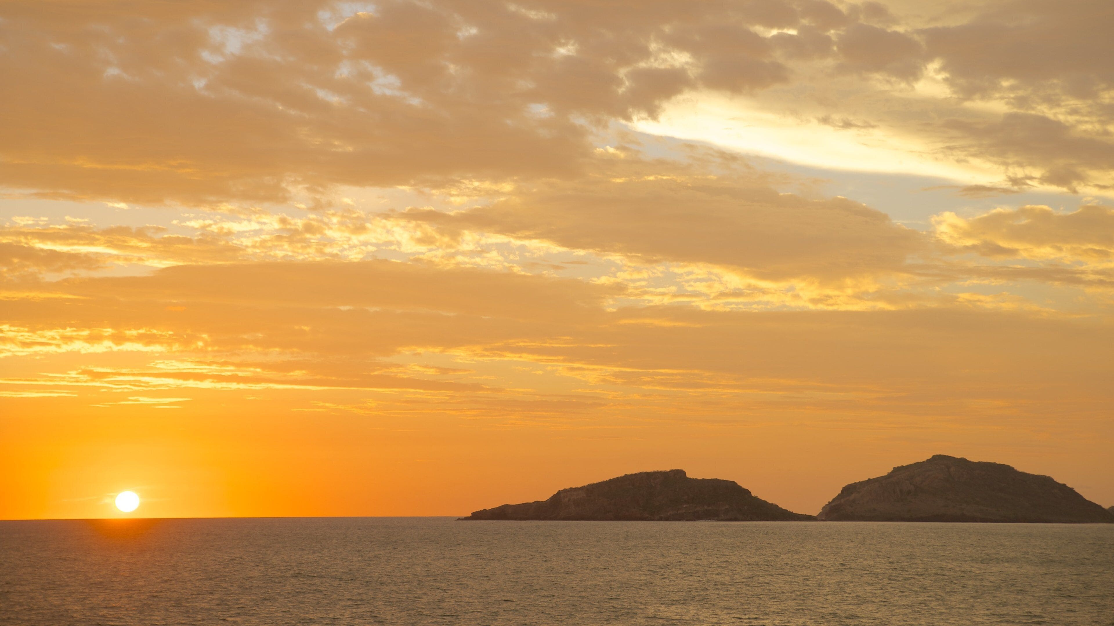 Olas Altas Beach which includes a sunset, general coastal views and island views