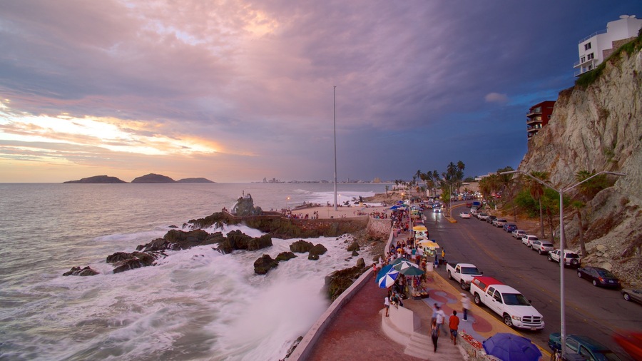 Olas Altas Beach featuring a sunset, street scenes and rugged coastline