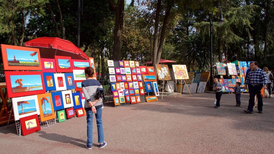 An outdoor art exhibition with various paintings displayed on easels and stands.