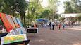 Un mercado de arte al aire libre, lleno de pinturas coloridas y gente.