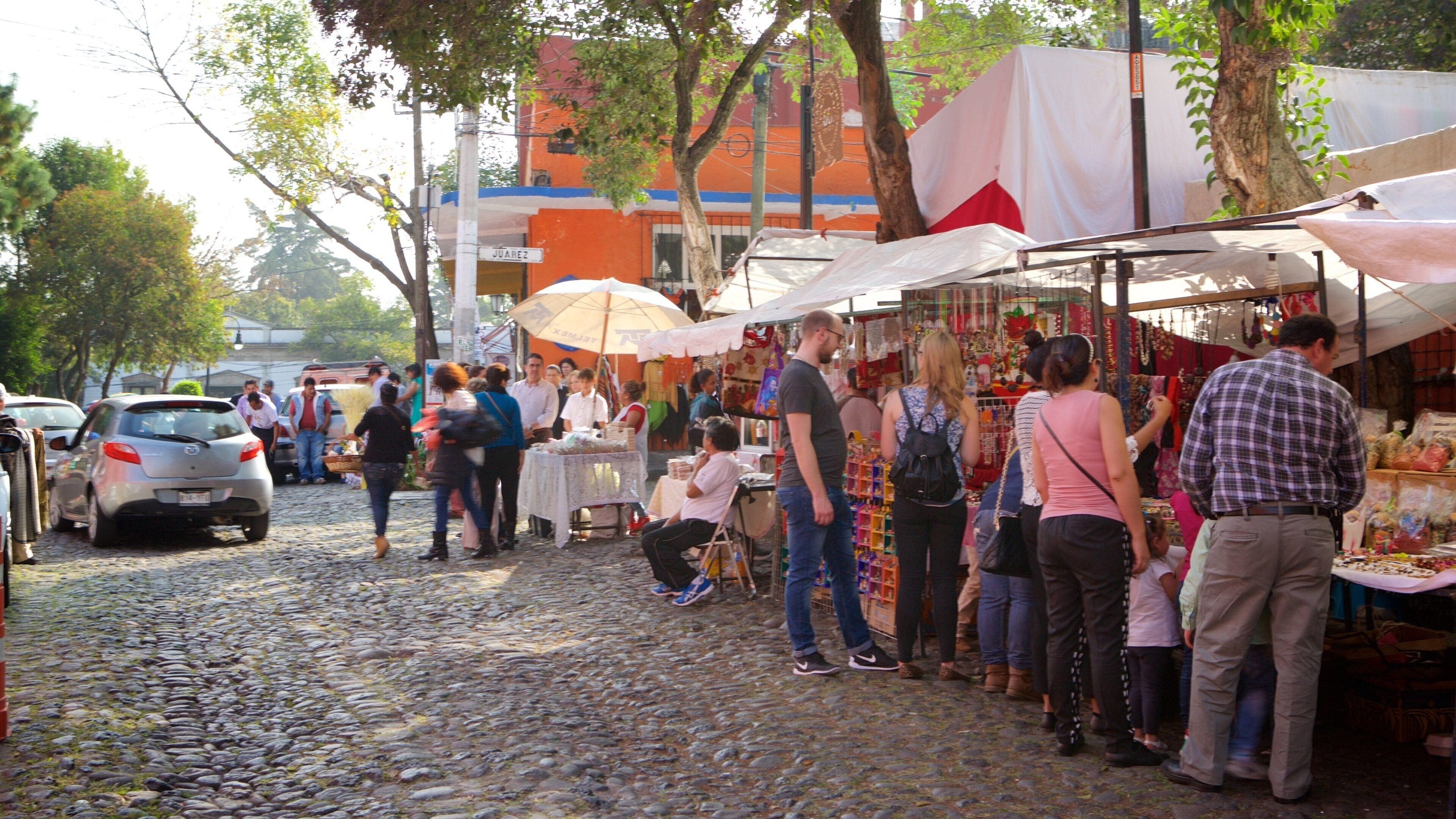San Jacinto Plaza showing markets as well as a small group of people