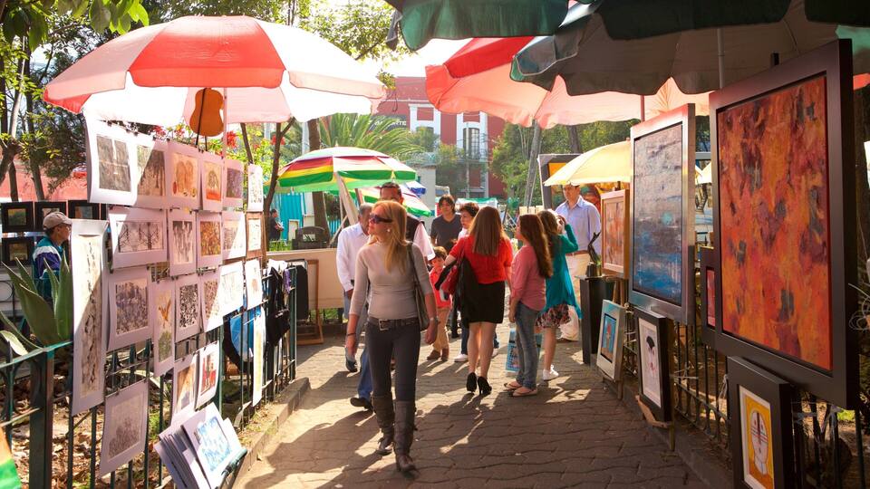 A pedestrian walkway lined with art displays and umbrellas.