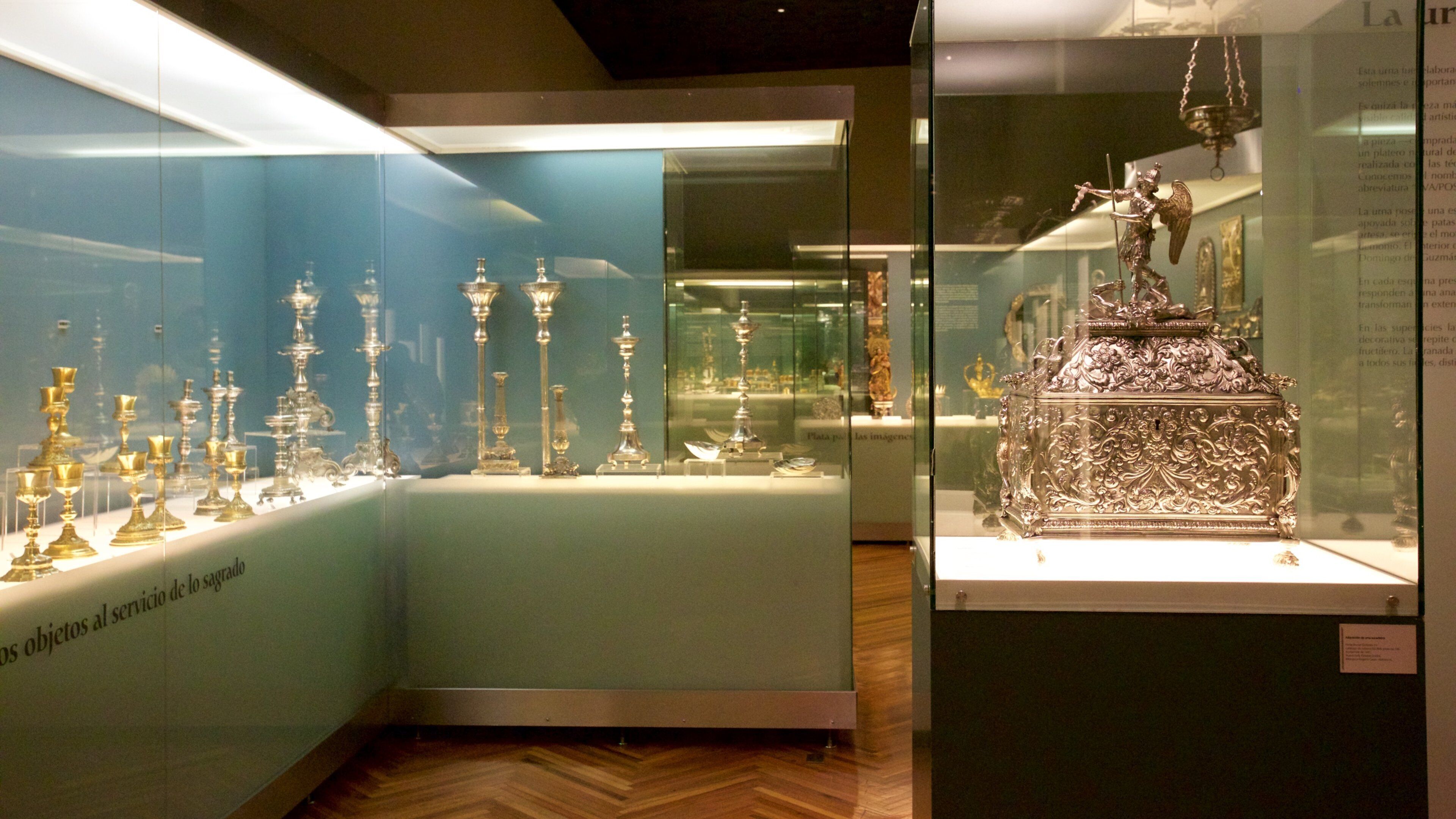 Een museumpresentatie van zilverbestek en een decoratieve zilveren doos.