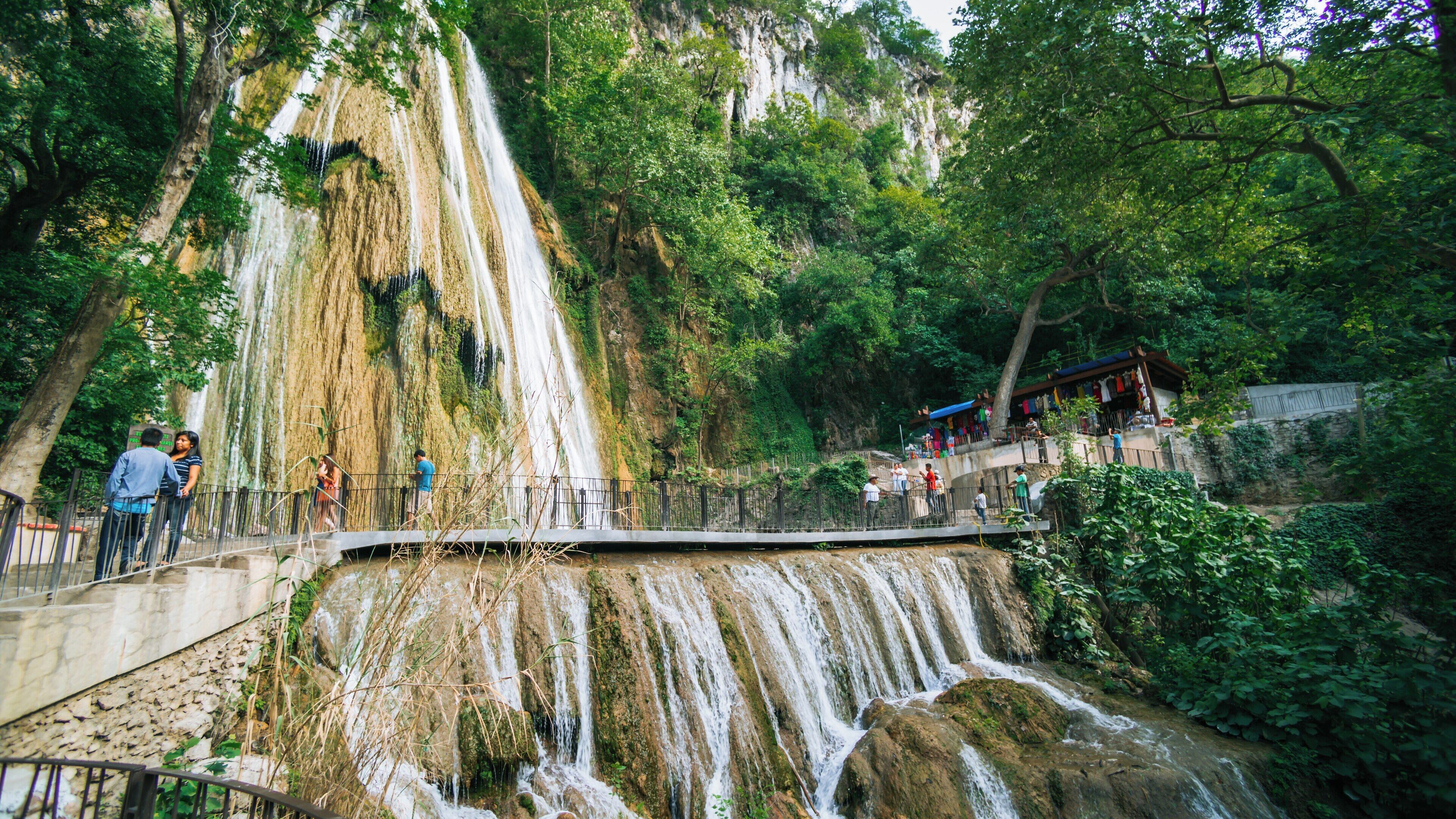 Majestic Cascada Cola de Caballo in Santiago, Nuevo Leon, Mexico, surrounded by lush greenery and visitors enjoying the serene atmosphere