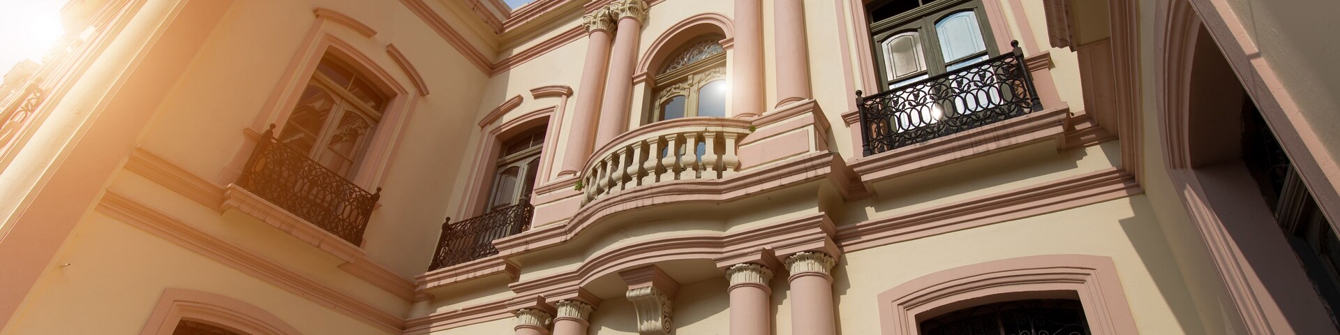 A classical building with ornate columns, arched windows, and decorative balconies.