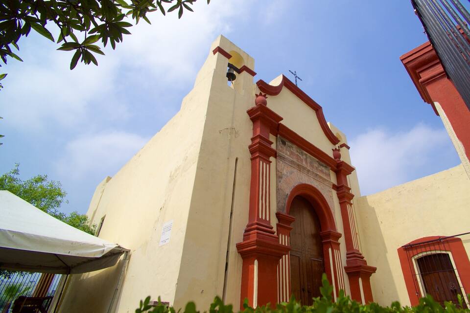 Een kerk met een hoge klokkentoren en een brede, gewelfde ingang.