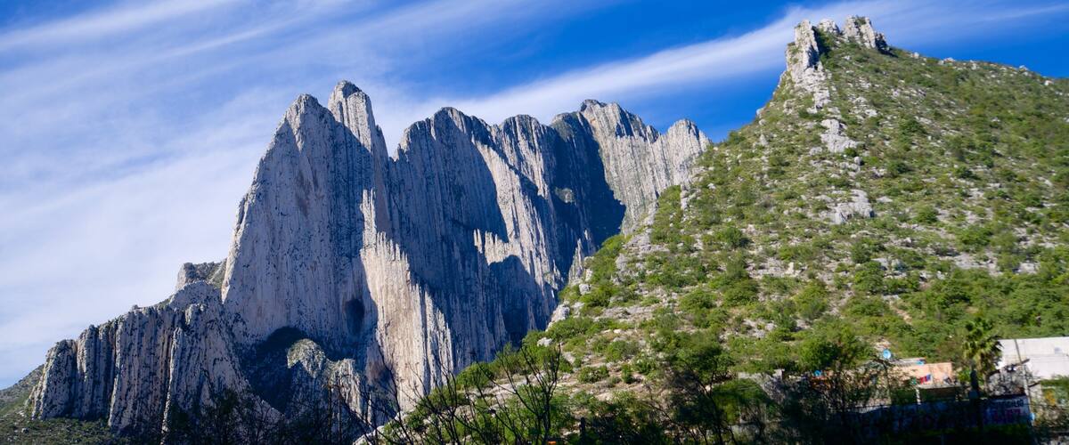 A mountain with steep cliffs and sparse vegetation.