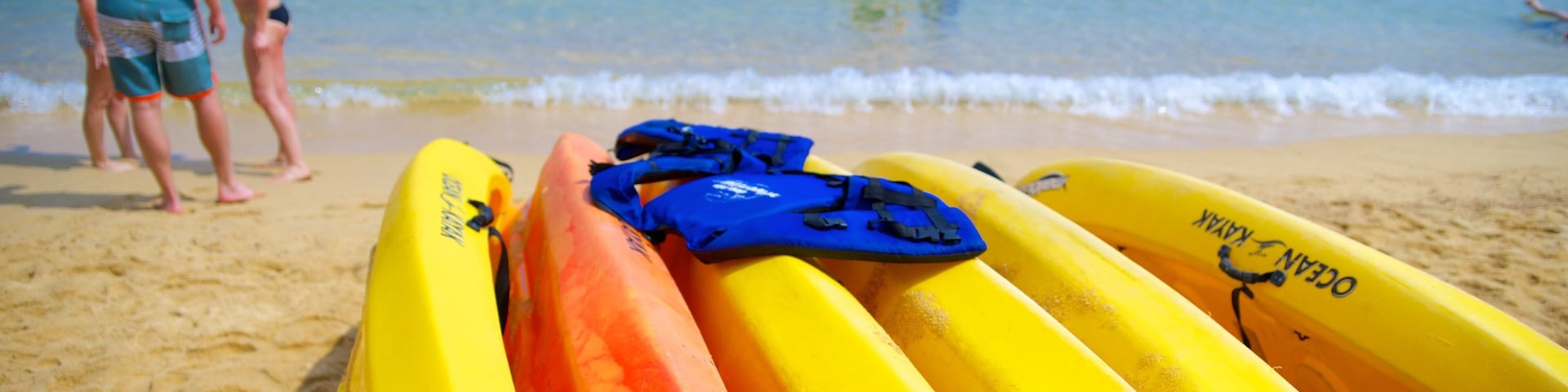 Las Caletas Beach featuring a sandy beach and kayaking or canoeing as well as a small group of people