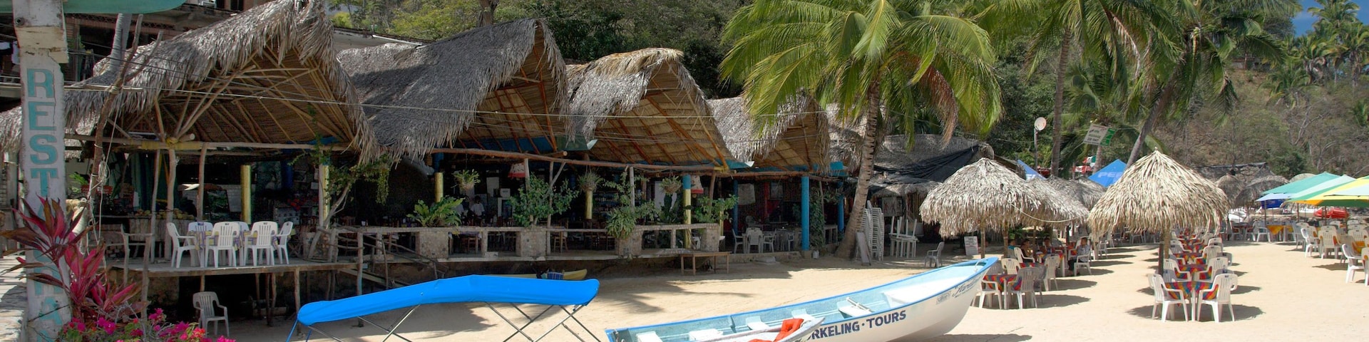 Mismaloya Beach with colorful boats and thatched shelters south of Puerto Vallarta Mexico