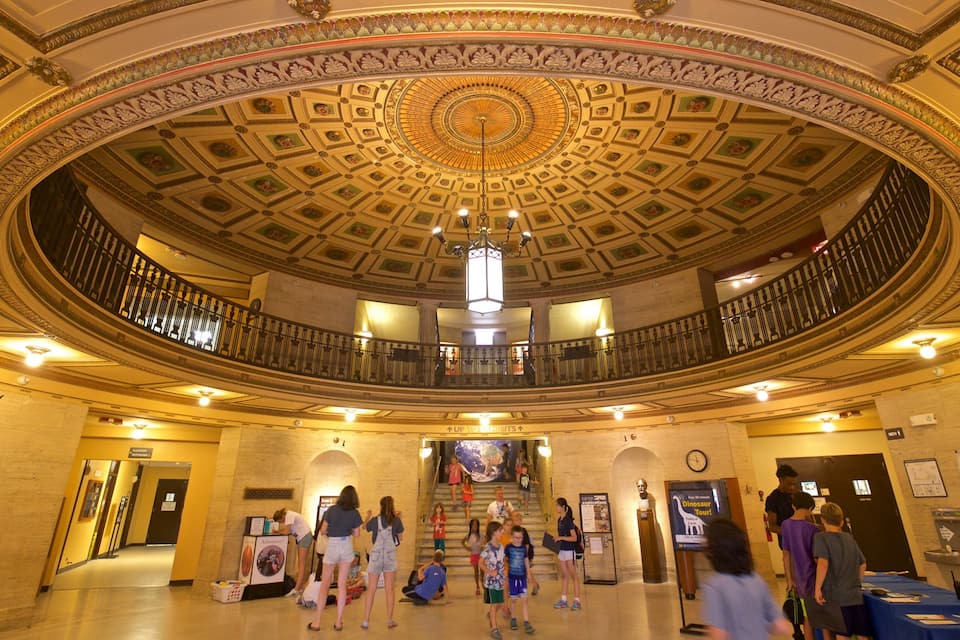 A grand, ornate lobby with a circular ceiling and a central chandelier.
