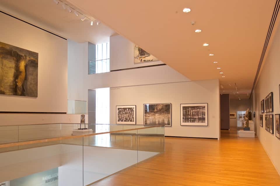 Eine Kunstgalerie mit Holzböden und Glasgeländern.