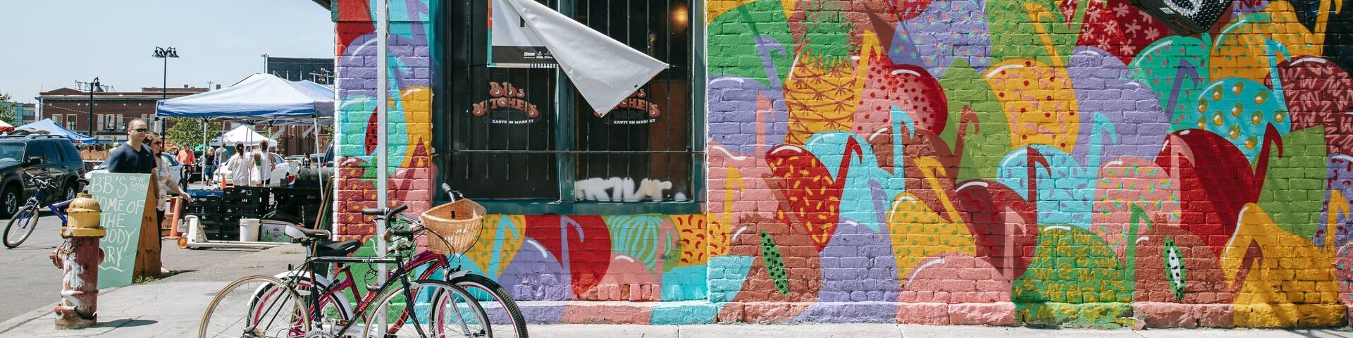 A colorful mural on a building, a stop sign, and bicycles parked on the sidewalk.