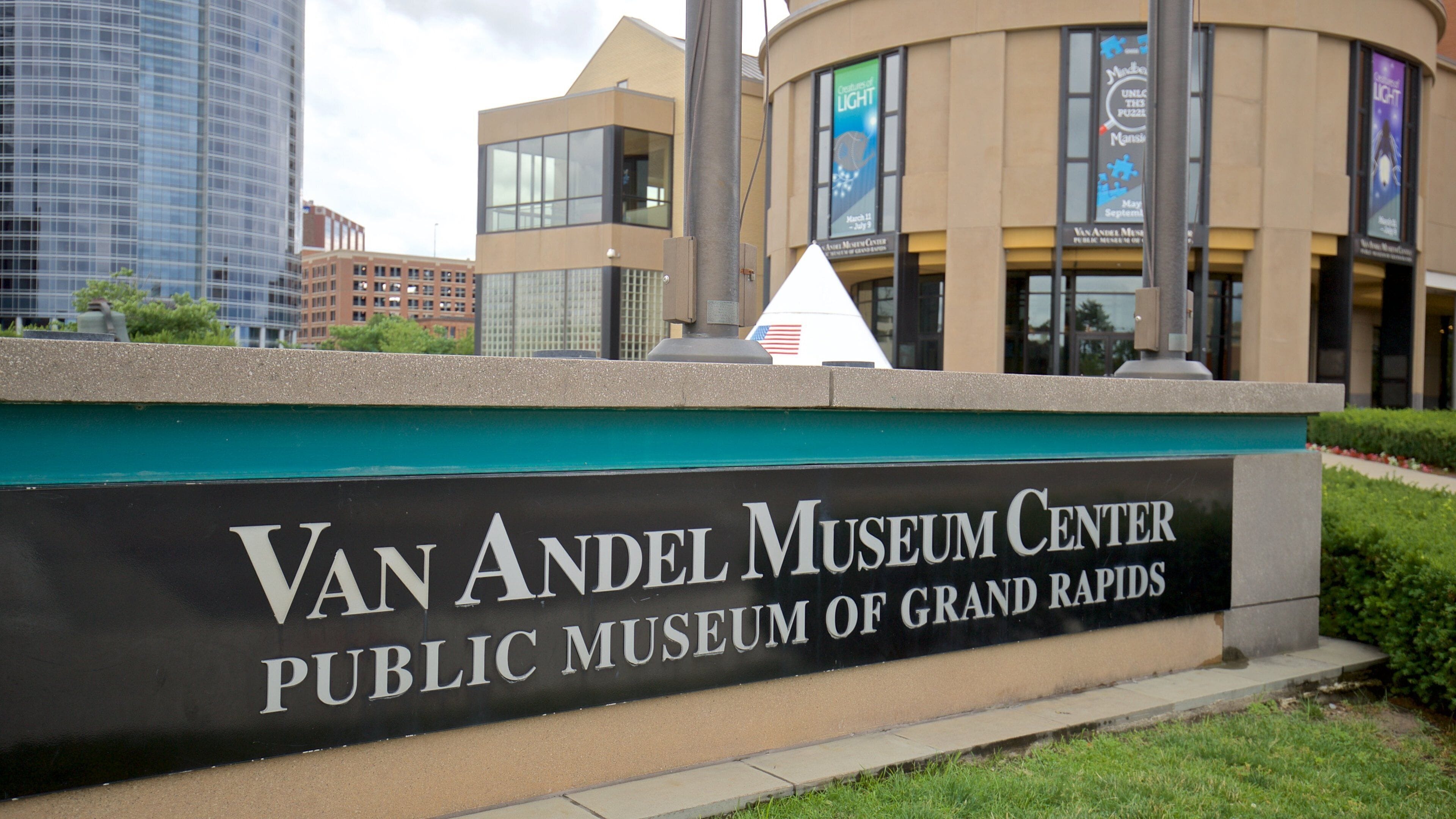 The Van Andel Museum Center sign with a view of modern buildings in the background.