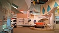 A vintage car display with a Corvette, surrounded by various car models and memorabilia.