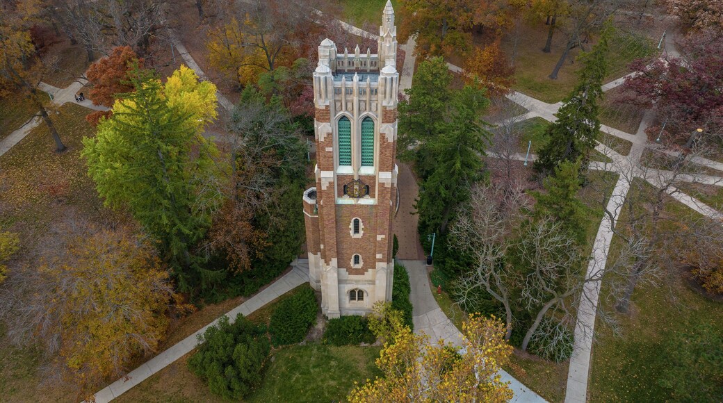 East Lansing, Michigan, United States - 04 November 2022: Aerial view of Beaumont Tower at Michigan State University surrounded by vibrant autumn trees and campus walkways.