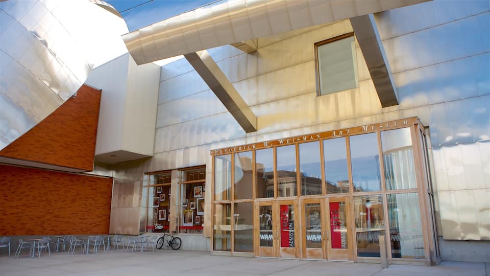 The exterior of the Frederick R. Weisman Art Museum with a modern design, large glass entrance, and outdoor seating area.