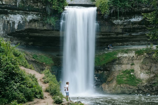 Minnehaha Park featuring a waterfall as well as an individual male