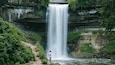 Minnehaha Park featuring a waterfall as well as an individual male