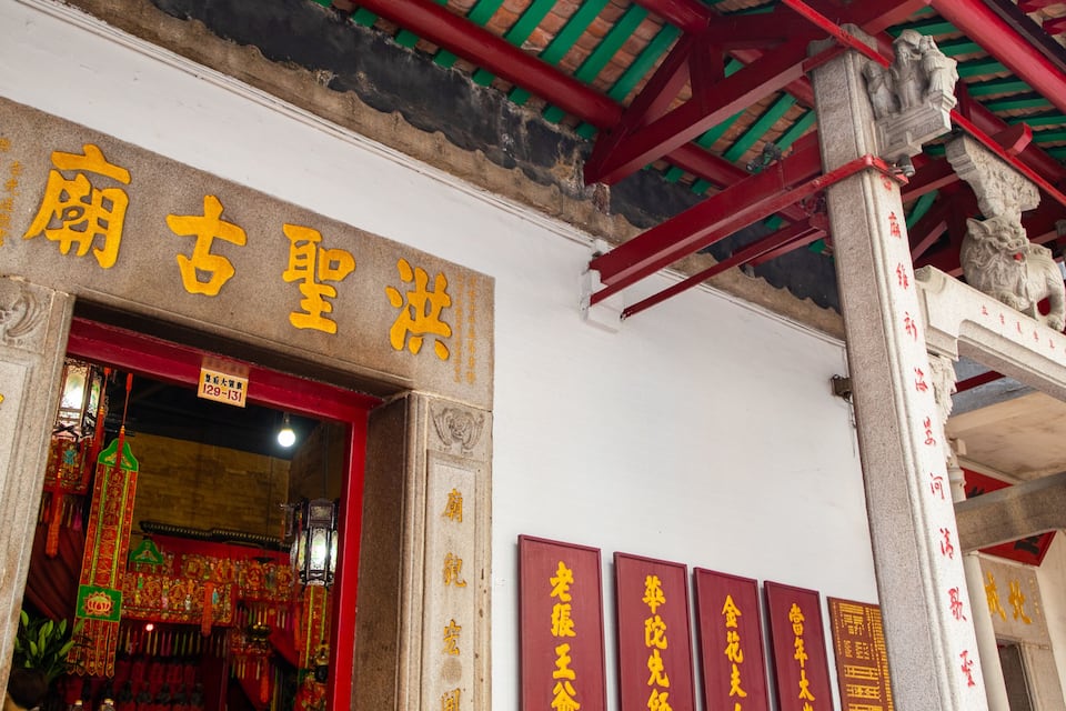 Een tempelpoort met Chinese karakters en traditionele architectuur.