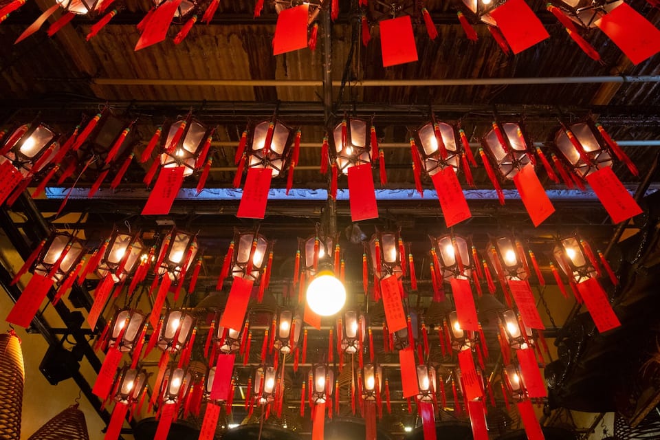 Een plafond met rode lantaarns en een centraal hanglamp.