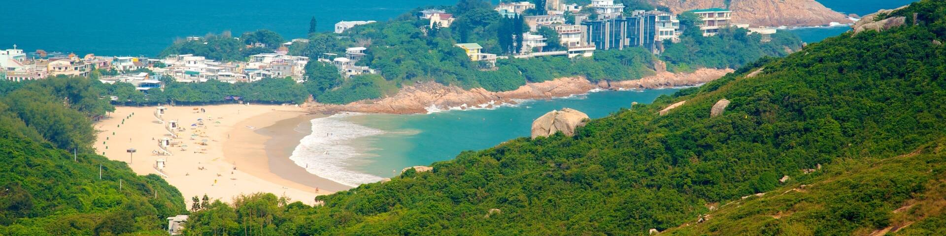 A coastal town with a beach, a lighthouse, and a mountain.