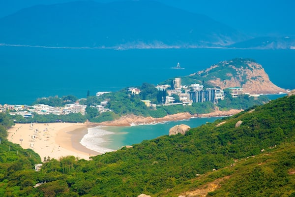 A coastal town with a beach, a lighthouse, and a mountain.