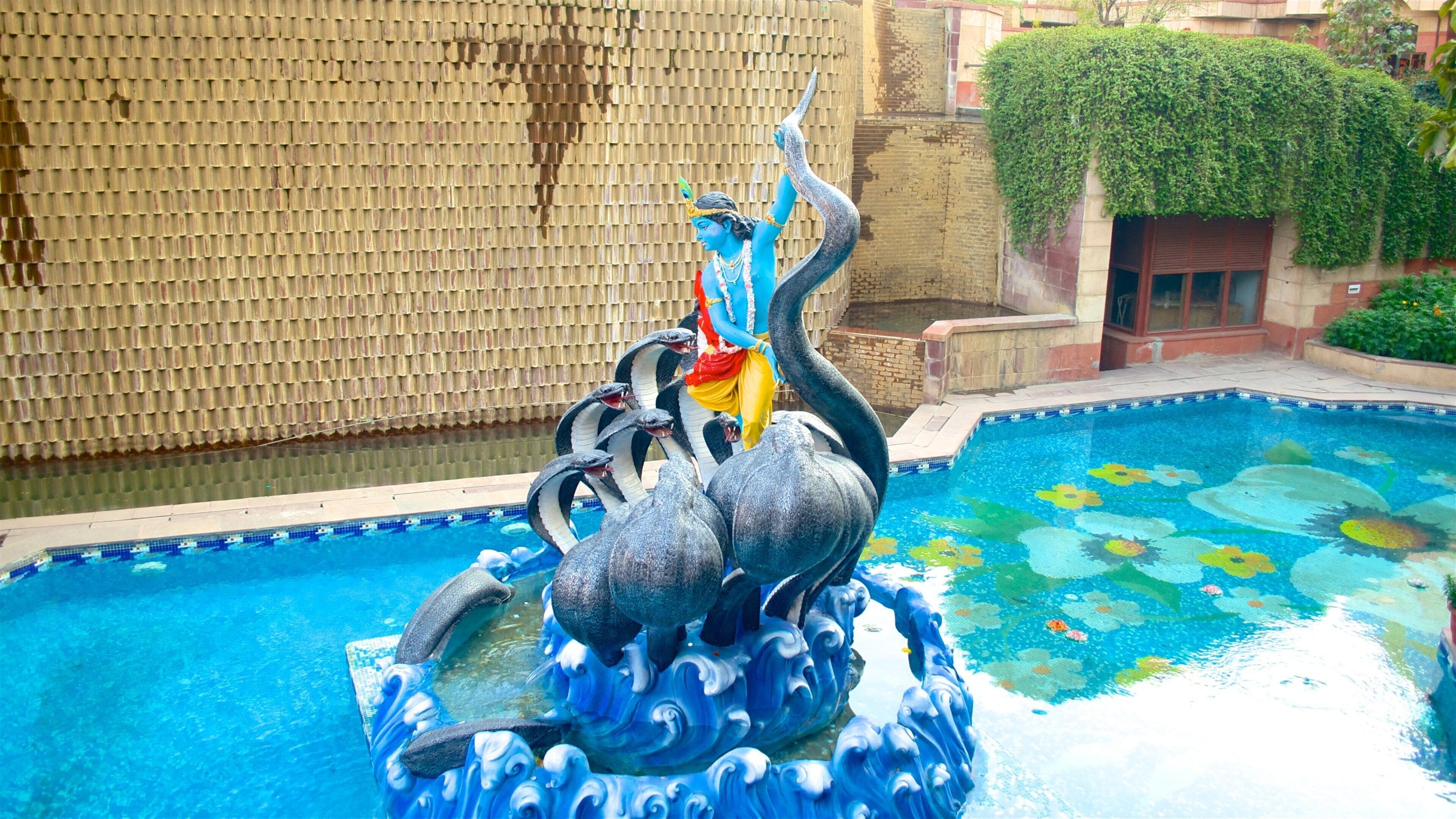 ISKCON Temple ofreciendo un templo o lugar de culto, una estatua o escultura y arte al aire libre