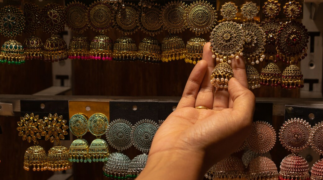 A hand of a woman selecting earrings on street market shop in Red fort, Delhi.