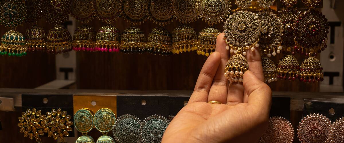 A hand of a woman selecting earrings on street market shop in Red fort, Delhi.