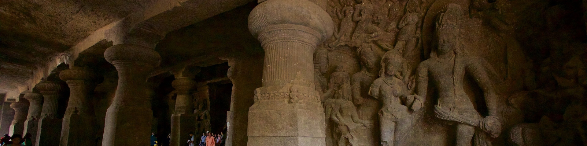 Eine uralte Höhle mit Steinmetzarbeiten und Säulen.