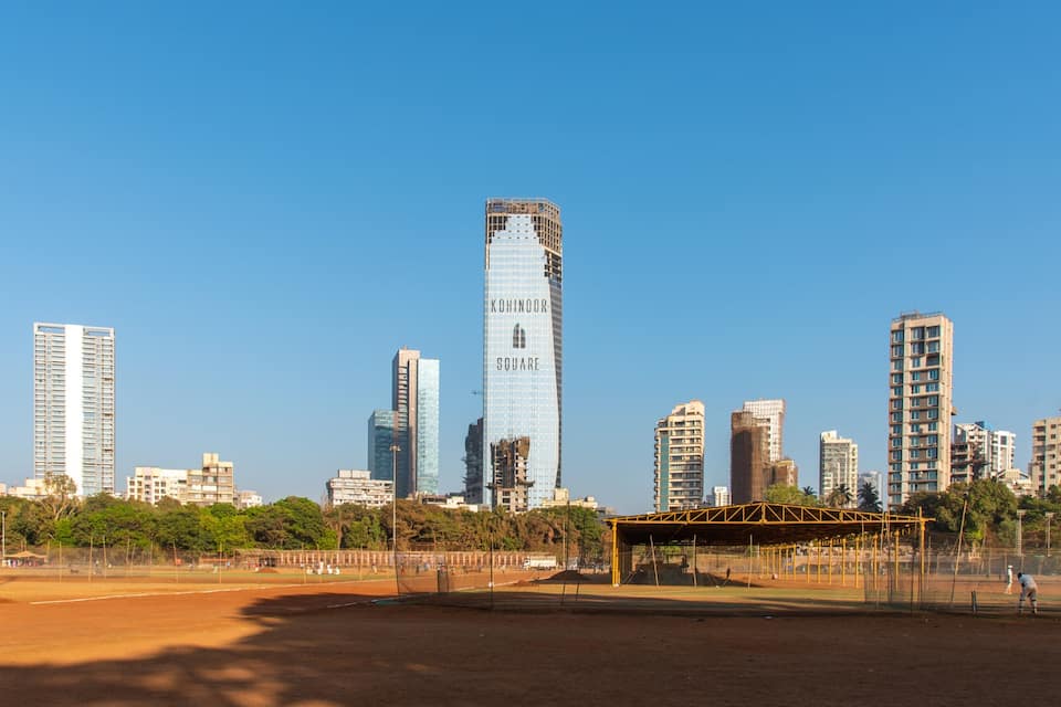 A baseball field with a city skyline in the background.