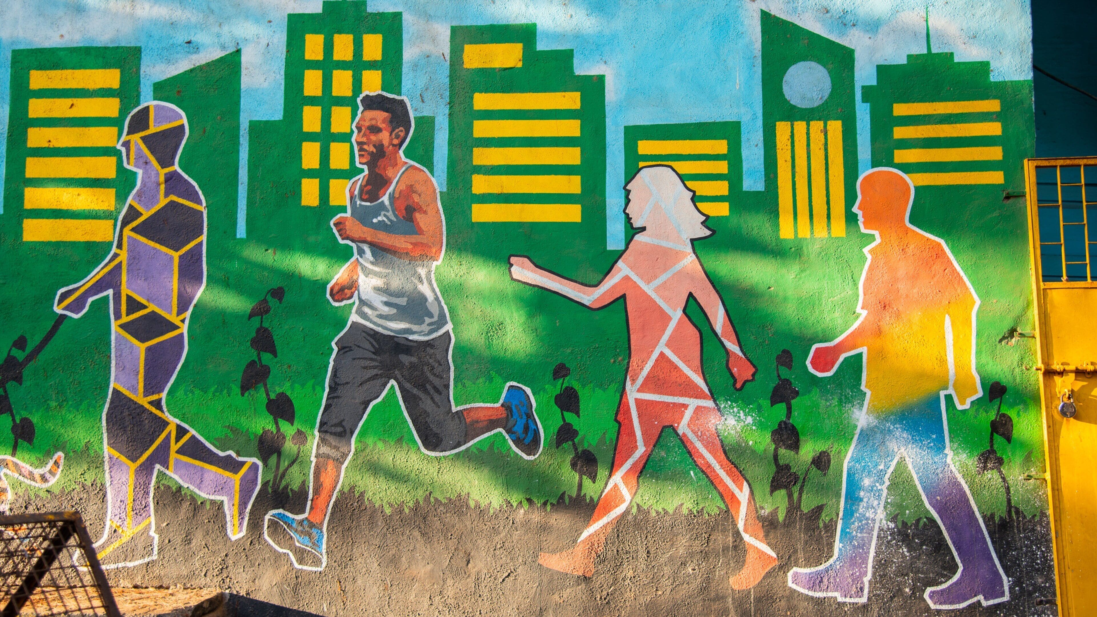 Un mural que muestra a tres personas corriendo, con edificios al fondo.