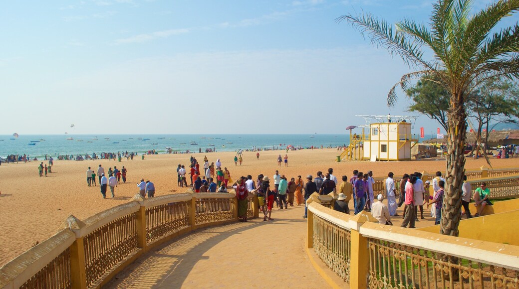 Calangute Beach which includes general coastal views and a sandy beach as well as a large group of people