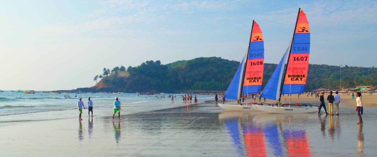 A beach with sailboats and people.
