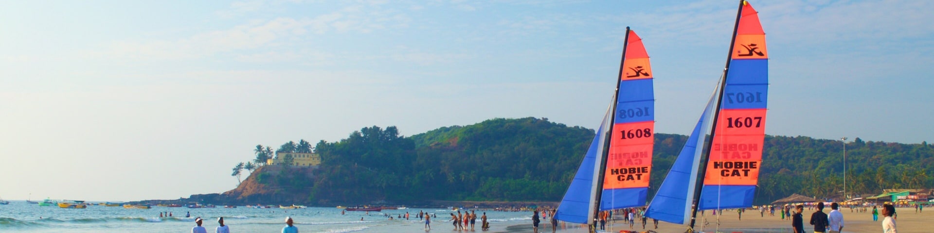 A beach with sailboats and people.