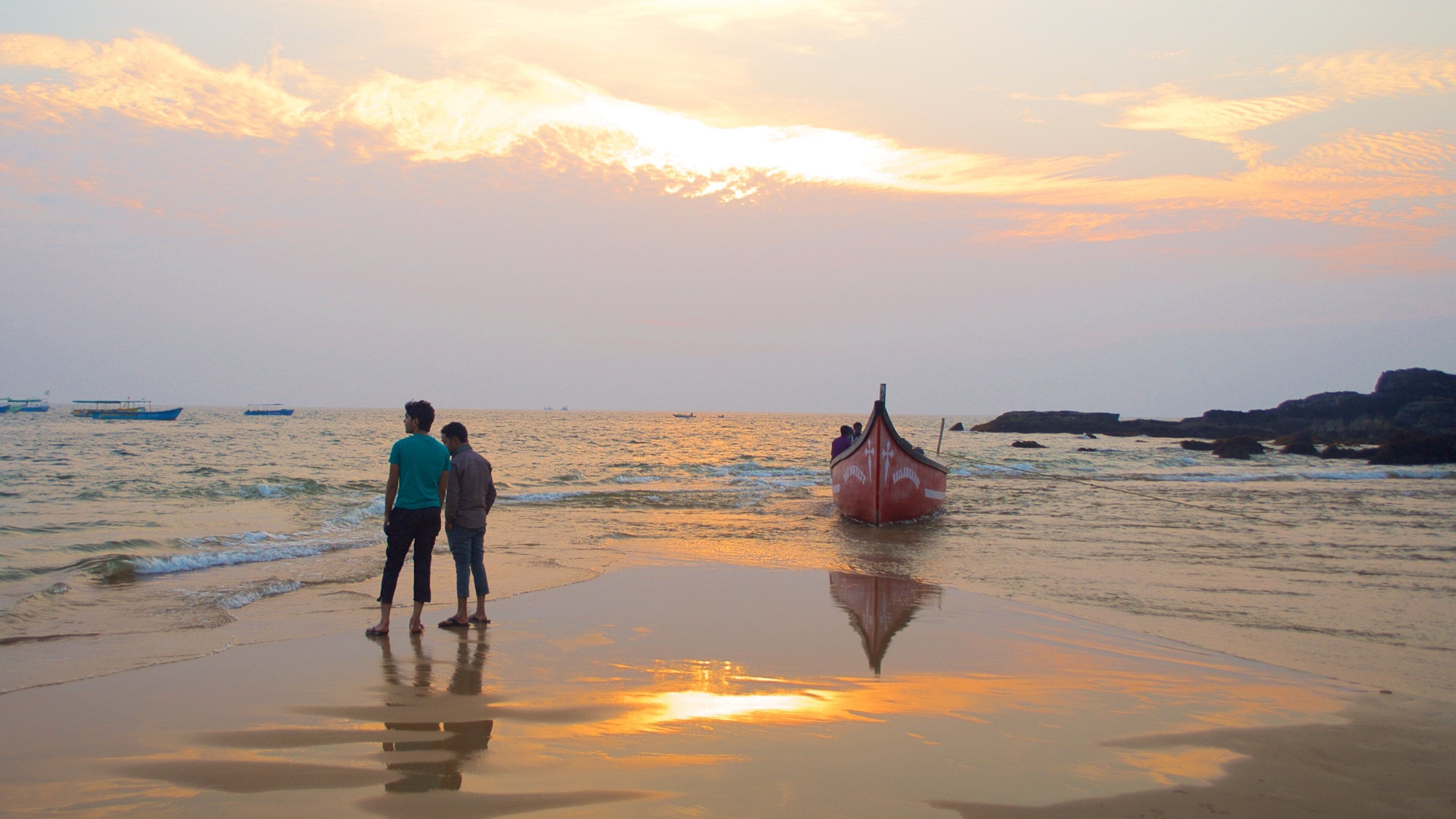 Baga Beach showing a sandy beach, a sunset and general coastal views