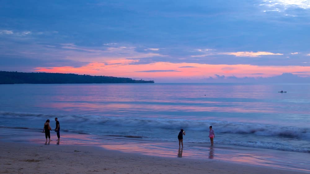 Jimbaran Beach featuring a sunset and a sandy beach