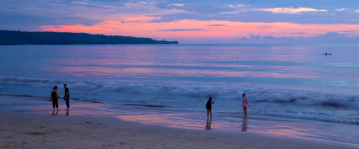 Jimbaran Beach featuring a sunset and a sandy beach