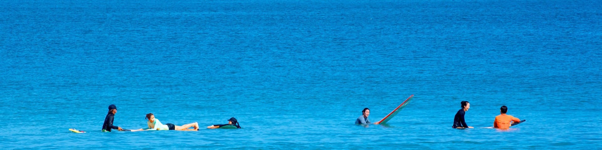 A group of people surfing in the ocean.