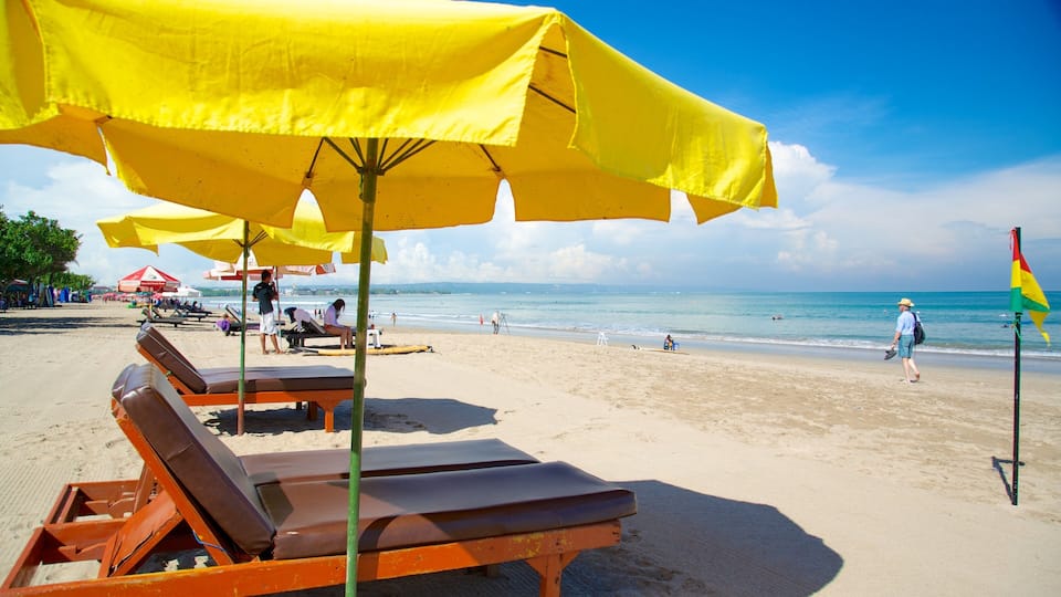 A beach with yellow umbrellas, sun loungers, and a flag.