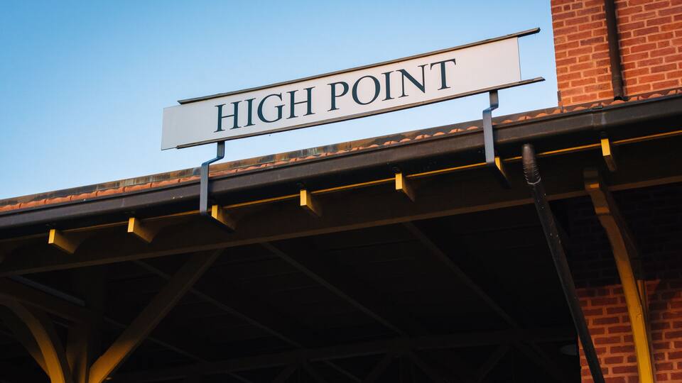 A 'HIGH POINT' sign mounted on a building's roof.