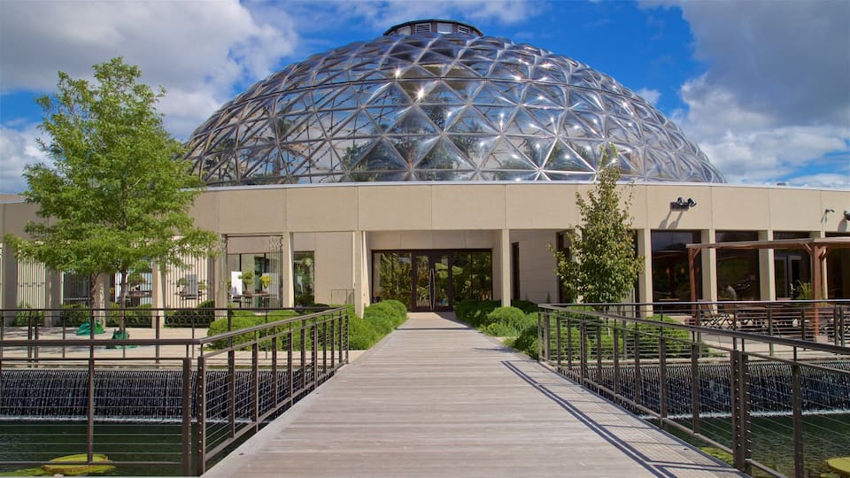 A large geodesic dome structure with a wooden walkway leading to its entrance.