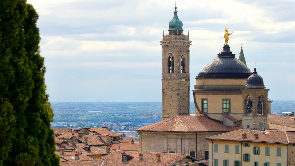 A historic tower with a bell, a dome, and a statue.