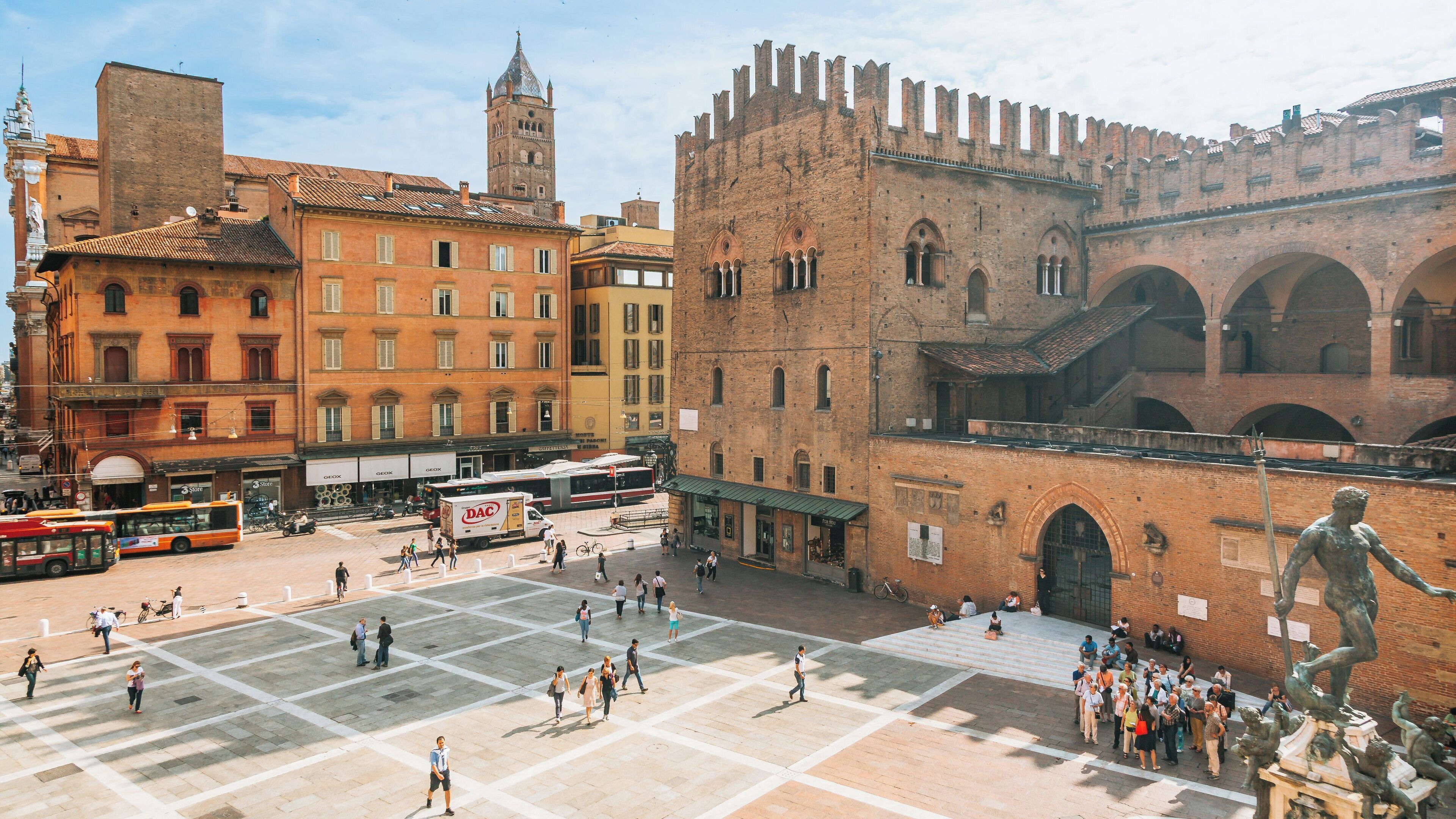 Exploring the vibrant square of Piazza Maggiore in the historic center of Bologna, Emilia-Romagna, Italy under a clear blue sky