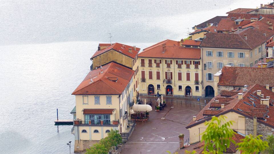 A waterfront street with historic buildings and a café.