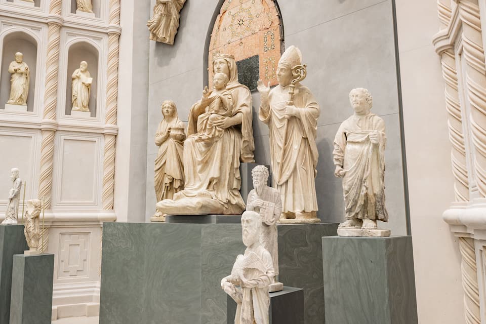 A collection of classical marble statues in a museum setting.