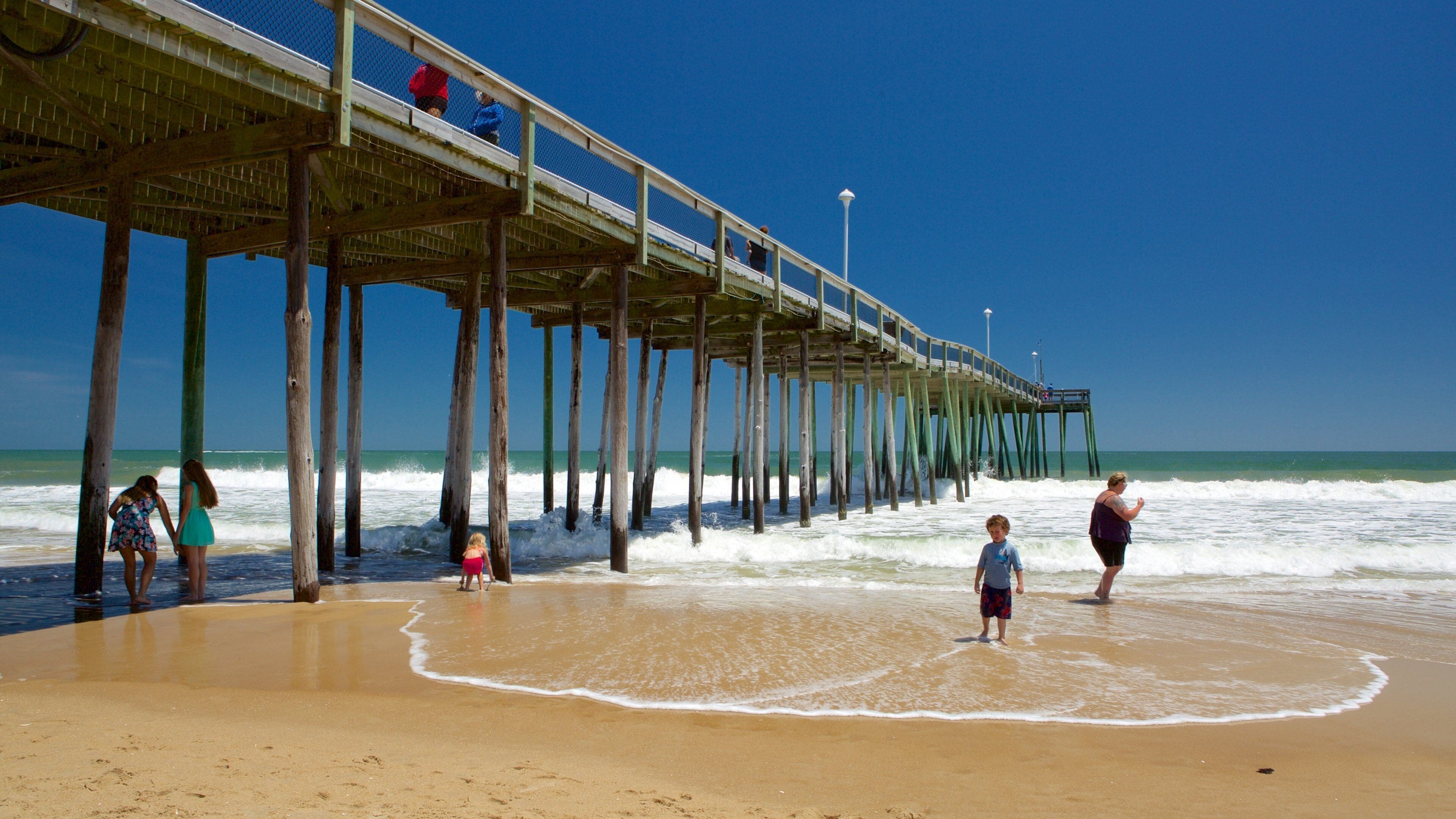 Ocean City Beach featuring surf and a sandy beach as well as a small group of people