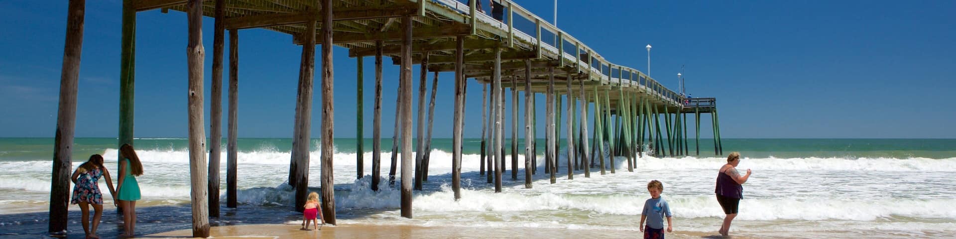 Ocean City Beach featuring surf and a sandy beach as well as a small group of people